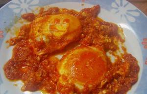 Fried eggs with tomatoes in olive oil