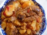 Kid with potatoes cooked in tomato sauce